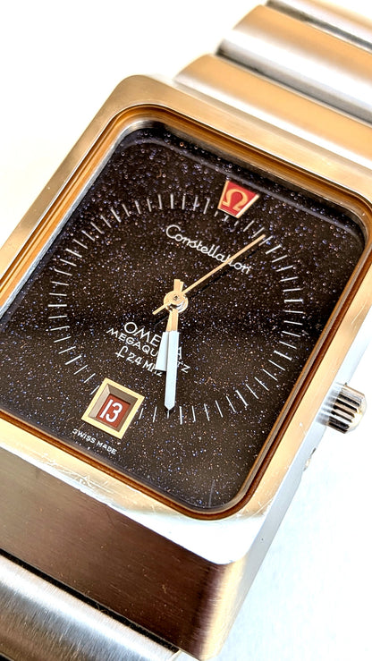 Omega Constellation Megaquartz gros plan cadran aventurine brun, index appliqués et guichet date, montre vintage homme