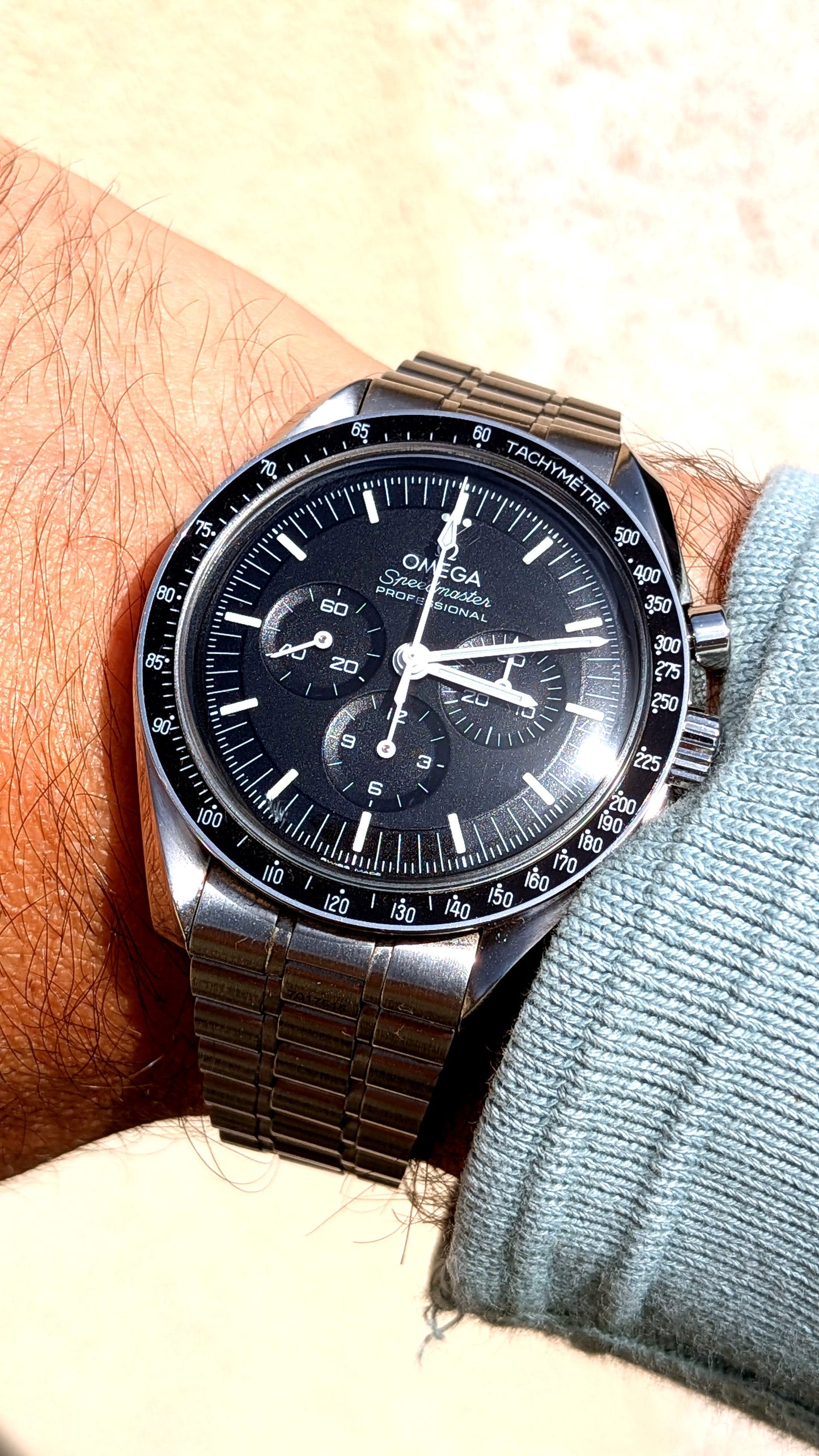 Omega Speedmaster Professional portée au poignet, cadran noir et bracelet acier, montre vintage homme