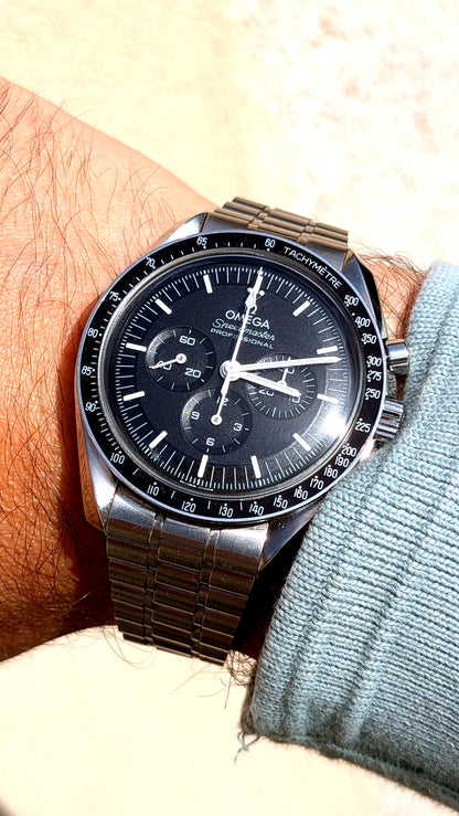 Omega Speedmaster Professional portée au poignet, cadran noir et bracelet acier, montre vintage homme