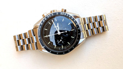 Omega Speedmaster Professional couchée de profil, couronne, poussoirs et bracelet acier, montre vintage homme