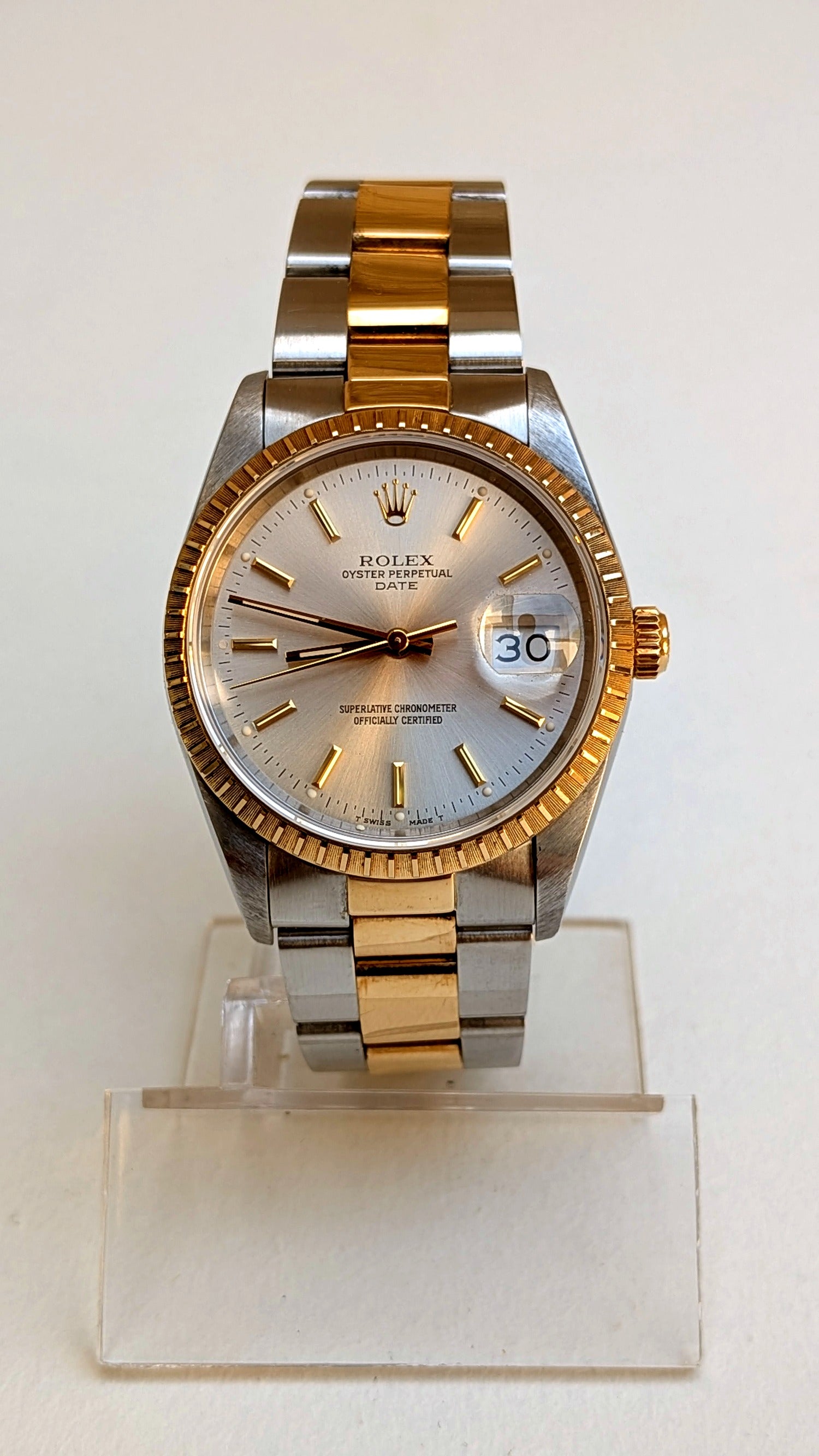 Rolex Oyster Perpetual Date de face sur support, index bâton or et bracelet acier-or, montre vintage homme