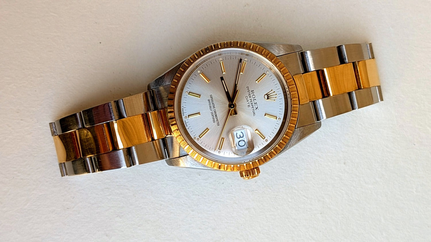 Rolex Oyster Perpetual Date à plat inclinée, cadran argenté guichet date et couronne or, montre vintage homme