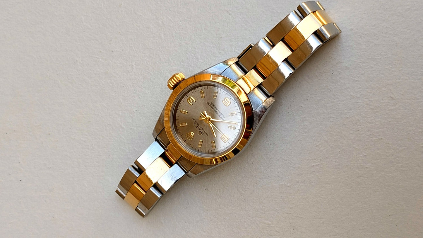 Rolex Oyster Perpetual à plat cadran argenté lunette or bombée bracelet Oyster acier-or, montre vintage femme