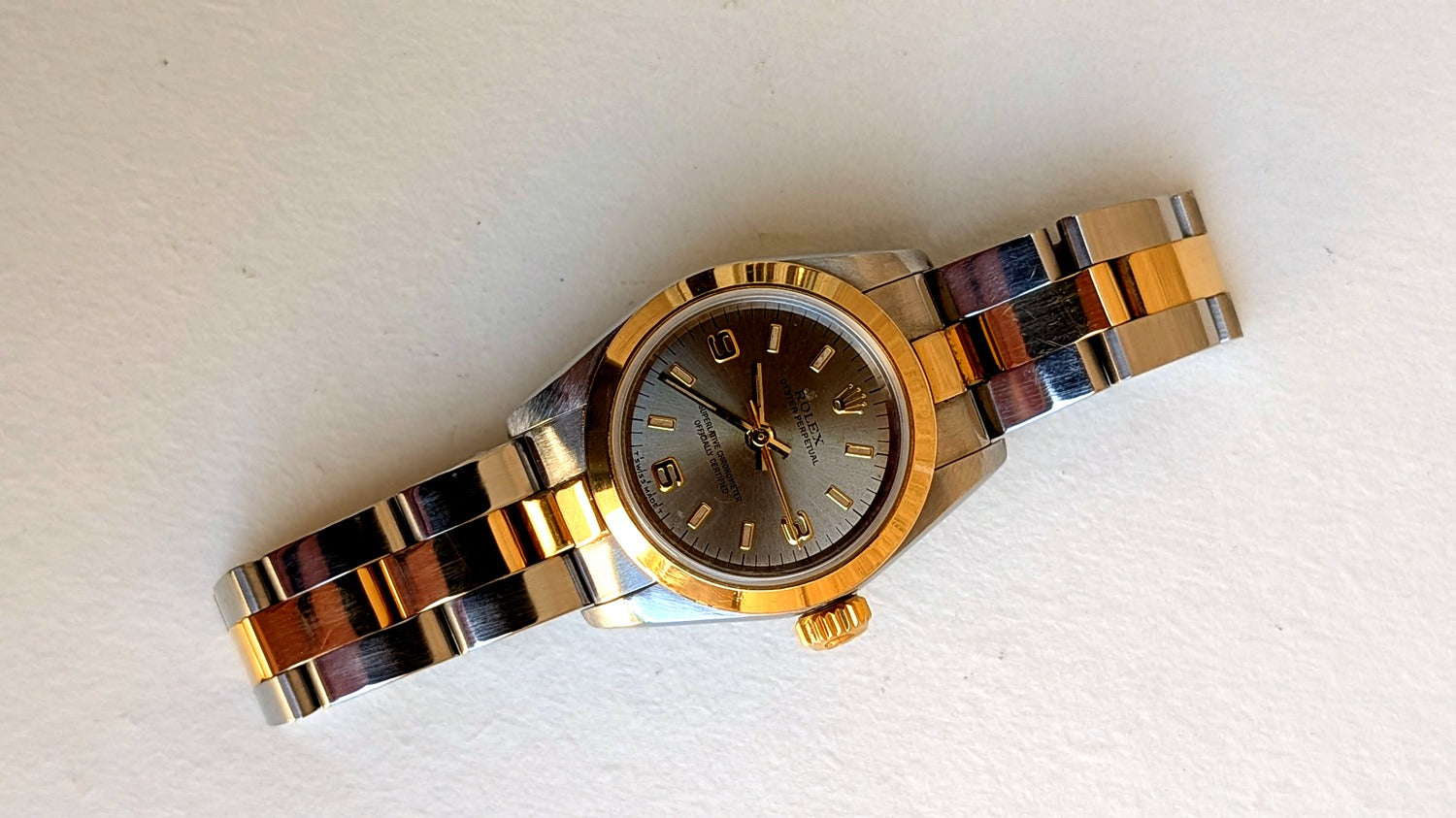 Rolex Oyster Perpetual à plat cadran argenté couronne or bracelet Oyster acier-or, montre vintage femme