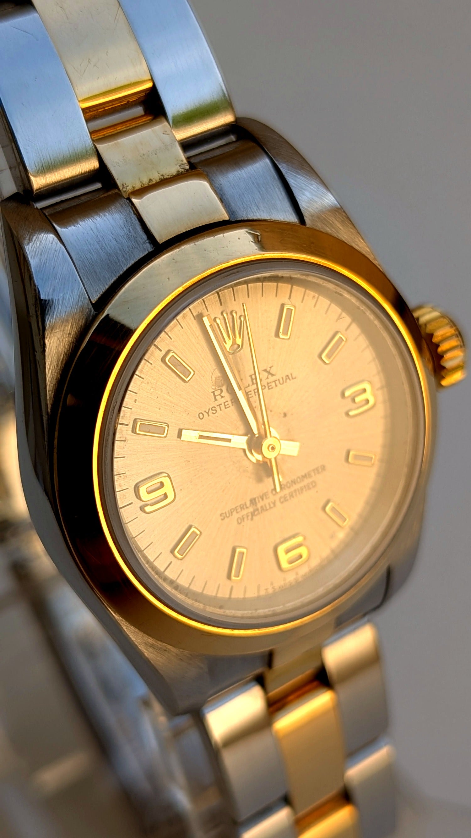 Rolex Oyster Perpetual gros plan cadran champagne lunette or chiffres 3-6-9, montre vintage femme