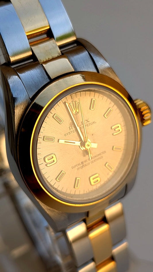 Rolex Oyster Perpetual gros plan cadran champagne lunette or chiffres 3-6-9, montre vintage femme
