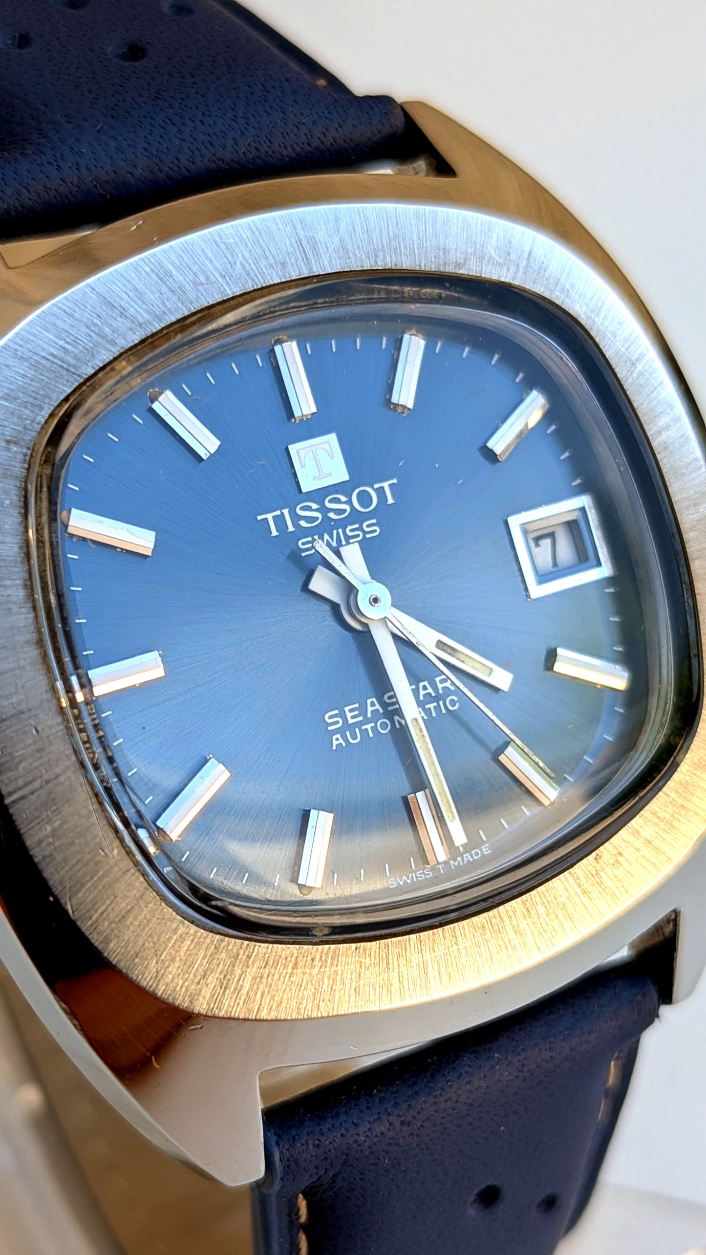 Tissot Seastar en gros plan, cadran bleu dégradé soleillé, index appliqués et logo Swiss, montre vintage homme